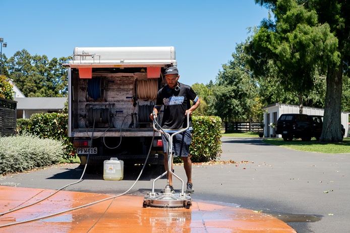 SoClean professional washing a driveway in Auckland using a surface cleaner