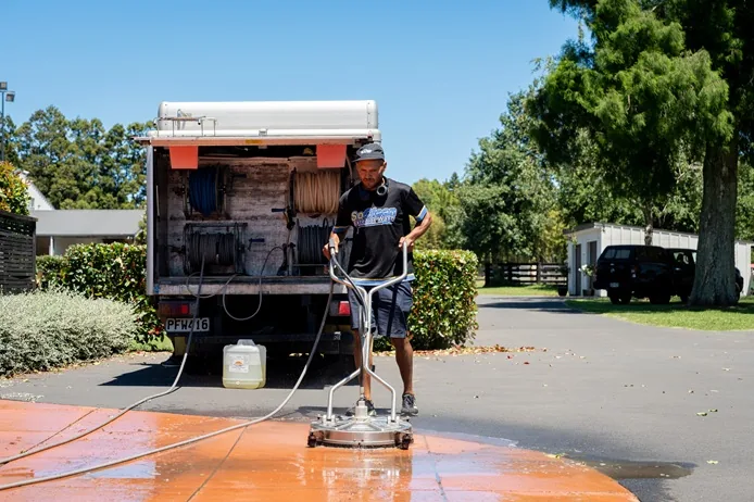 SoClean professional washing a driveway in Auckland using a surface cleaner